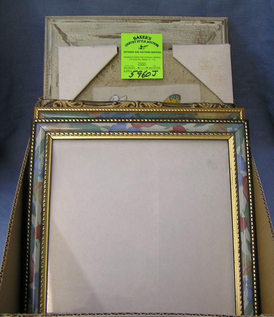 Box full of vintage picture frames some with artwork: Box full of vintage picture frames some with artwork est. value $65.00-$75.00