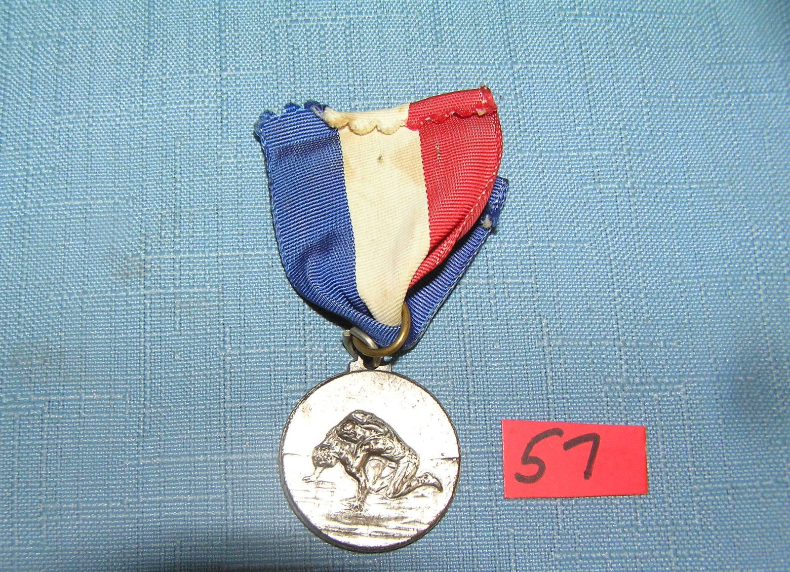 Antique silver toned wrestling medal and ribbon: Antique silver toned wrestling medal and ribbon est. value $40.00-$50.00