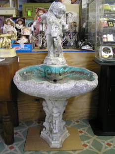 Antique seashell shaped bird bath: Antique seashell shaped bird bath with large putti figure holding fish that disperses flowing water through his mouth, base has a series of four putti figures as well, original water pump included