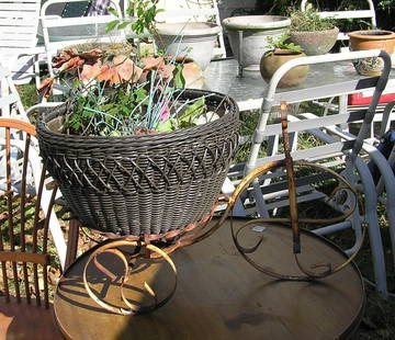 Wrought iron tricycle and planter garden piece: Wrought iron tricycle and planter garden piece 24 inches long by 13 inches wide by 14 1/2 inches high consists of 2 pieces all metal 3 wheel tricycle and a wicker planter est. value $65.00-$75.00