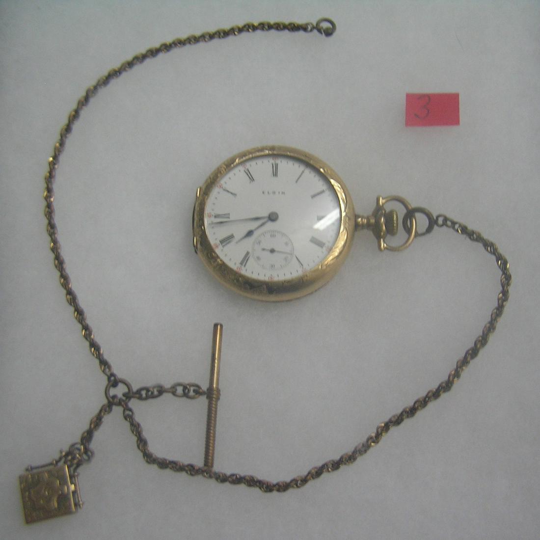 Antique Elgin pocket watch: Antique Elgin pocket watch with minuite and second hand dials in gold filled case, 15 jewels, case dated 1909 with baby photo watch, also has watch chain and locket fob est. value $500.00-$600.00