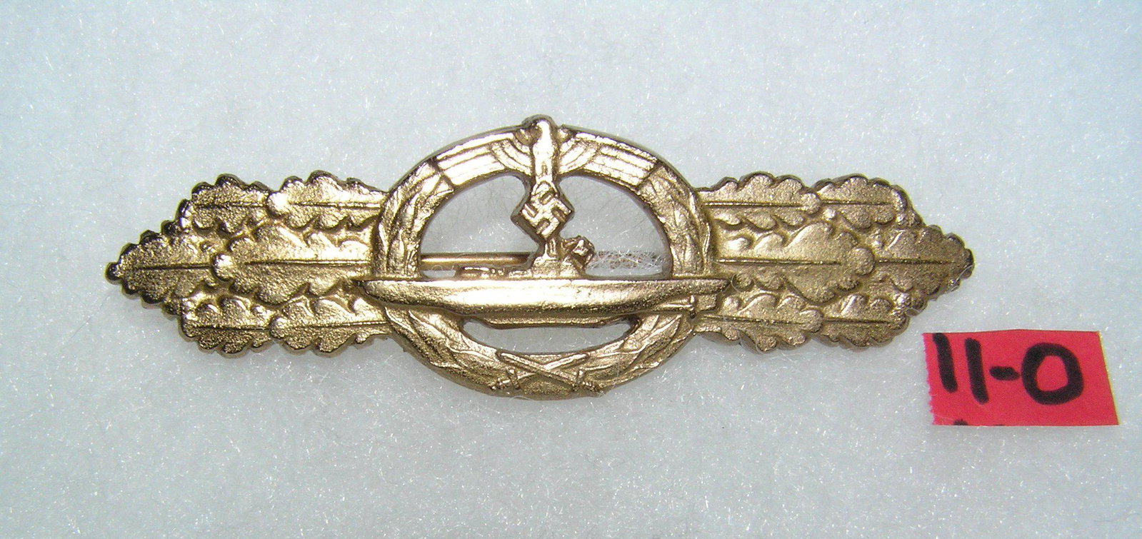 German submarine combart badge WWII style: German submarine combart badge gold colored with pin back WWII style high quality reproduction collectors, re-enactors,historical or theatrical collectors piece est. value $80.00-$100.00