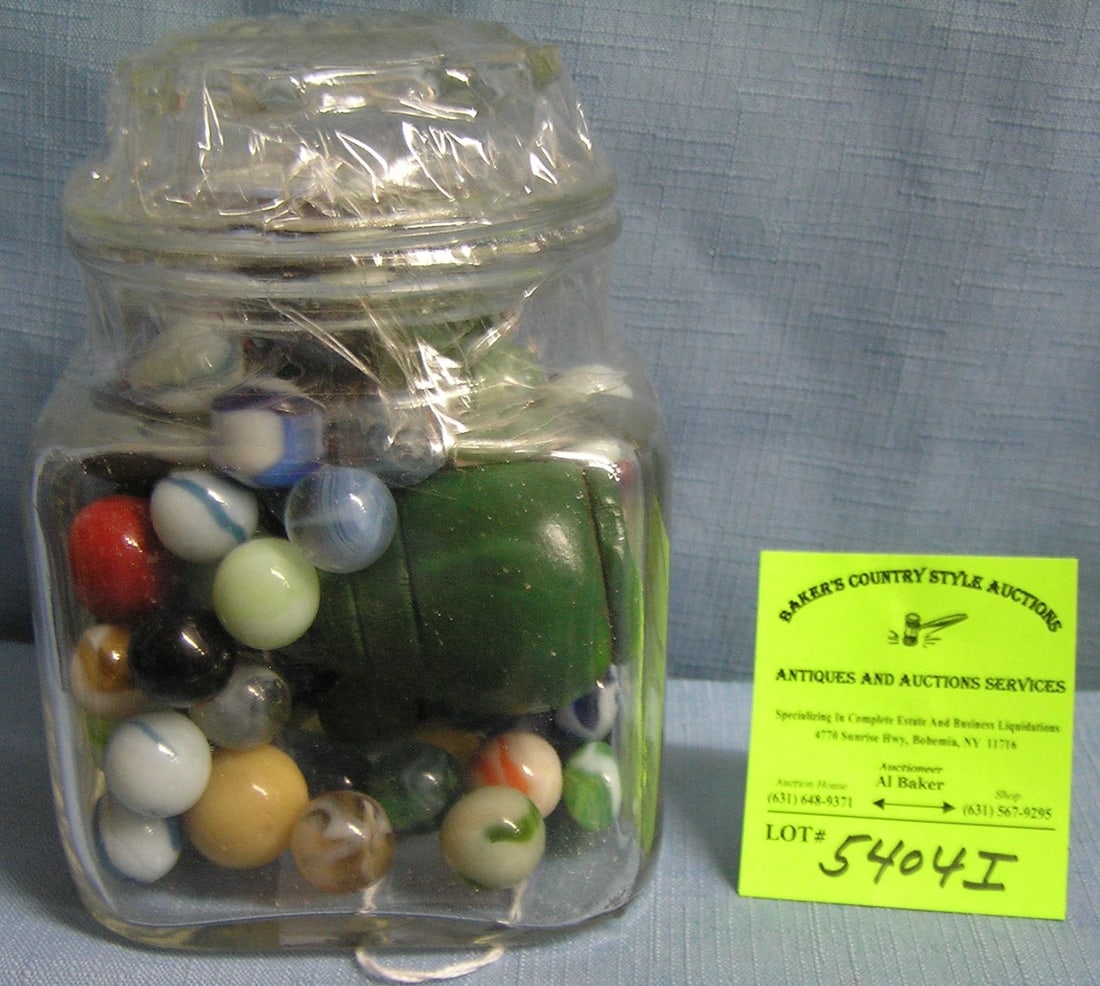 Glass jar full of marbles and wooden spinning top: Glass jar full of marbles and wooden spinning top est. value $100.00-$125.00