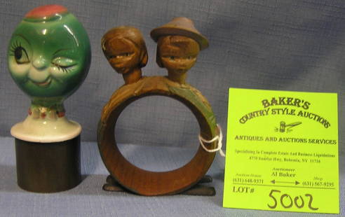 Hand carved figural wooden napkin ring: Hand carved figural wooden napkin ring with nodding figural heads and a porcelain figural liquor bottle stopper this piece condition as found crack to neck area $75.00-$100.00