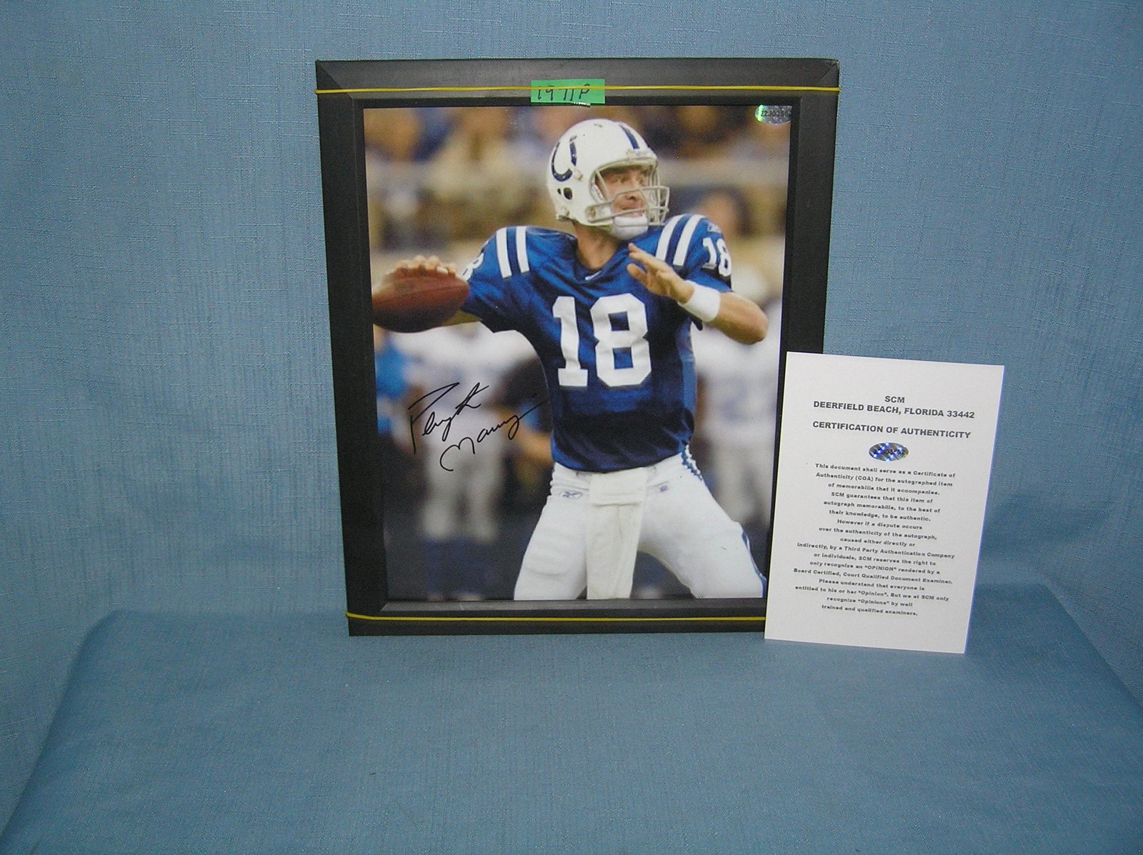 Autographed Peyton Manning 8 by 10 color photo: Autographed Peyton Manning 8 by 10 color photo with certificae of authenticity, framed, frame is in condition as found est. value $200.00-$250.00