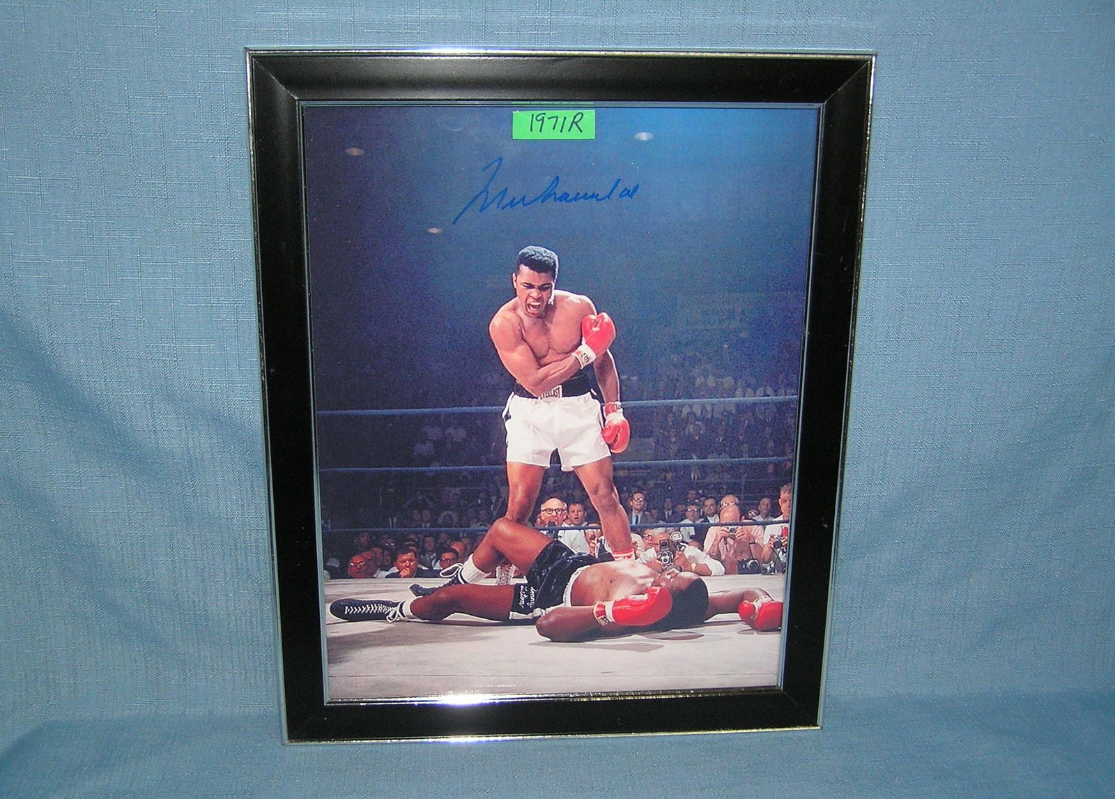 Muhammed Ali Autographed 8 by 10 color photo: Muhammed Ali Autographed 8 by 10 color photo with certificae of authenticity featuring the knock out of Sonny Liston est. value $200.00-$300.00