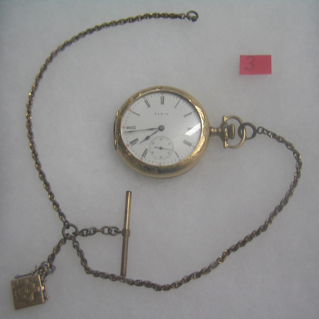 Antique Elgin pocket watch: Antique Elgin pocket watch with minuite and second hand dials in gold filled case, 15 jewels, case dated 1909 with baby photo watch, also has watch chain and locket fob est. value $500.00-$600.00
