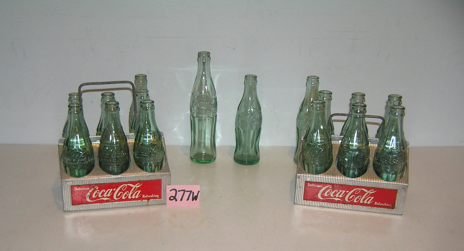 Collection of Coca Cola bottles and 2 early carriers: Collection of Coca Cola bottles and 2 early carriers circa 1940's and 1950's est. value $ 150.00-$175.00