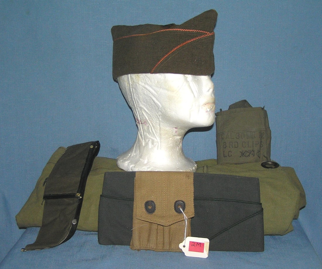 Group of vintage military collectibles: Group of vintage military collectibles includes a WWI ammo pouch, WWII overseas cap, Vietnam duffle bag and more est. value $125.00-$150.00