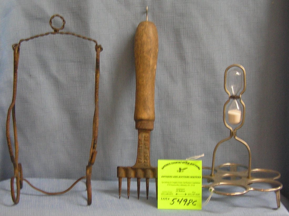 Group of three metal ware items: Group of three metal ware items includes a egg holder and timer, unsual brass Victorian stand and a unusual Hamilton beach kitchen tool $40.00-$50.00