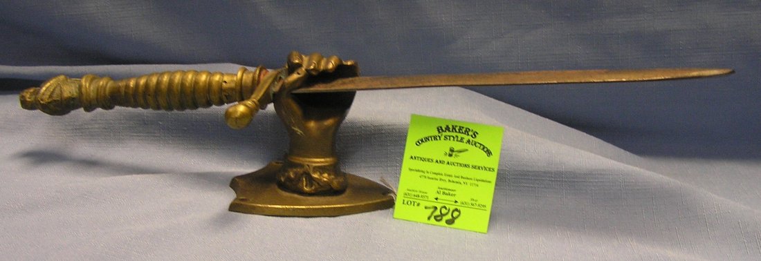 Antique brass and steel dagger: Antique brass and steel dagger with solid brass hand shaped wall mounted holder dagger has knight in shining armor hand grip, 16" est. value $275.00-$300.00