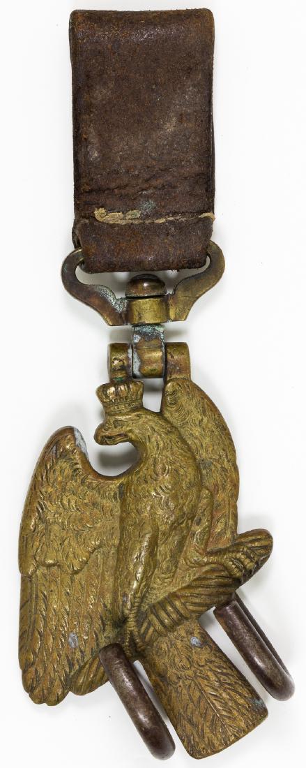 PRUSSIAN IMPERIAL ARMY DRUM HANGER: PRUSSIAN IMPERIAL ARMY DRUM HANGER Solid brass Prussian Imperial army drum hanger, with two hooks, 3 1/2" x 6" with 3" tall leather loop sewn to swivel at top. Very good.
