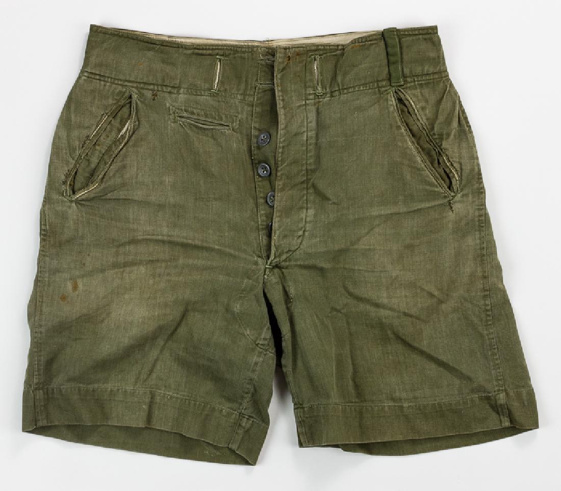 AFRIKA KORPS SHORTS: AFRIKA KORPS SHORTS Olive-drab shorts of the type used by the Afrika Korps throughout German involvement in the North African campaign of 1941-1943. They feature two slash hip pockets with a small wat
