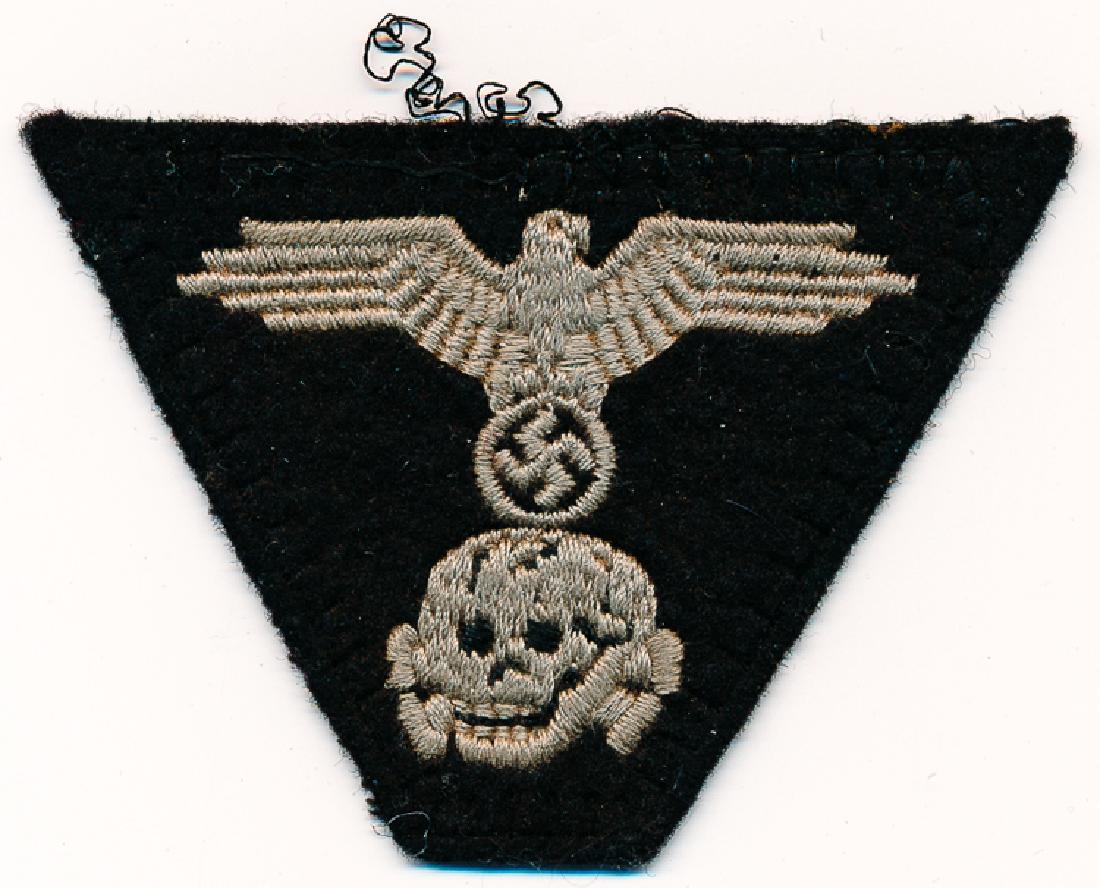 WAFFEN-SS PANZER HAT PATCH: WAFFEN-SS PANZER HAT PATCH Trapezoidal black felt patch, approx. 2" x 2 3/4", depicting a death's head beneath a national eagle in silver thread. The patch was taken from an M43 hat worn by Waffen-SS
