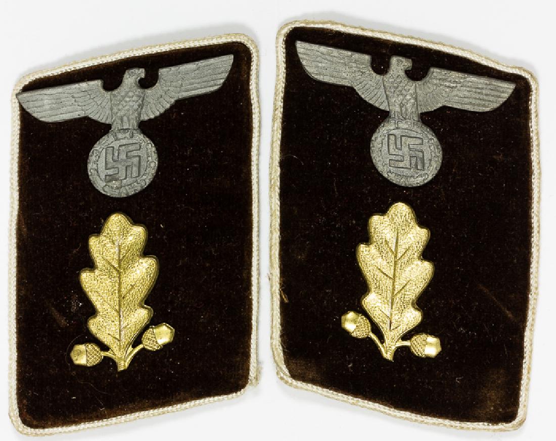 NSDAP KREIS ABSCHNITTSLEITER COLLAR TABS: NSDAP KREIS ABSCHNITTSLEITER COLLAR TABS Matched pair of brown velvet collar tabs, each 2 3/4" x 2", each bearing a single gold oak leaf and a gray metal national eagle, with white piping. The left-ha