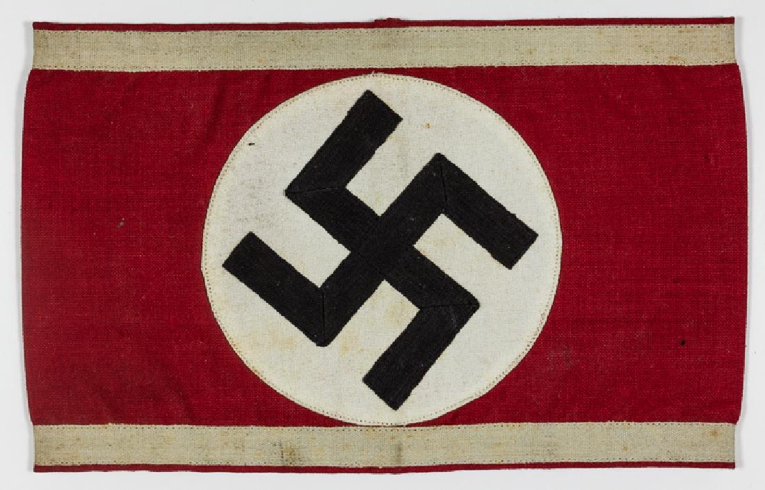 SA RESERVE ARMBAND: SA RESERVE ARMBAND NSDAP armband, 7 1/2" x 4 1/2", constructed of red fabric with a white disk applied to the center, containing a mobile swastika of black ribbon. The edges are trimmed with white rib