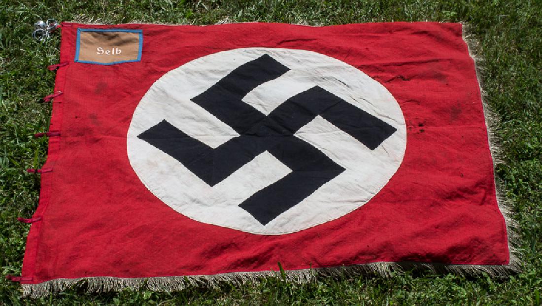 N.S.D.A.P. "ORTSGRUPPE" FLAG: N.S.D.A.P. "ORTSGRUPPE" FLAG Large Third Reich flag, 56" x 47", an "Ortsgruppe" ("local group") flag from the Bavarian town of Selb. The flag is constructed for red wool bunting with a large sewn-on w