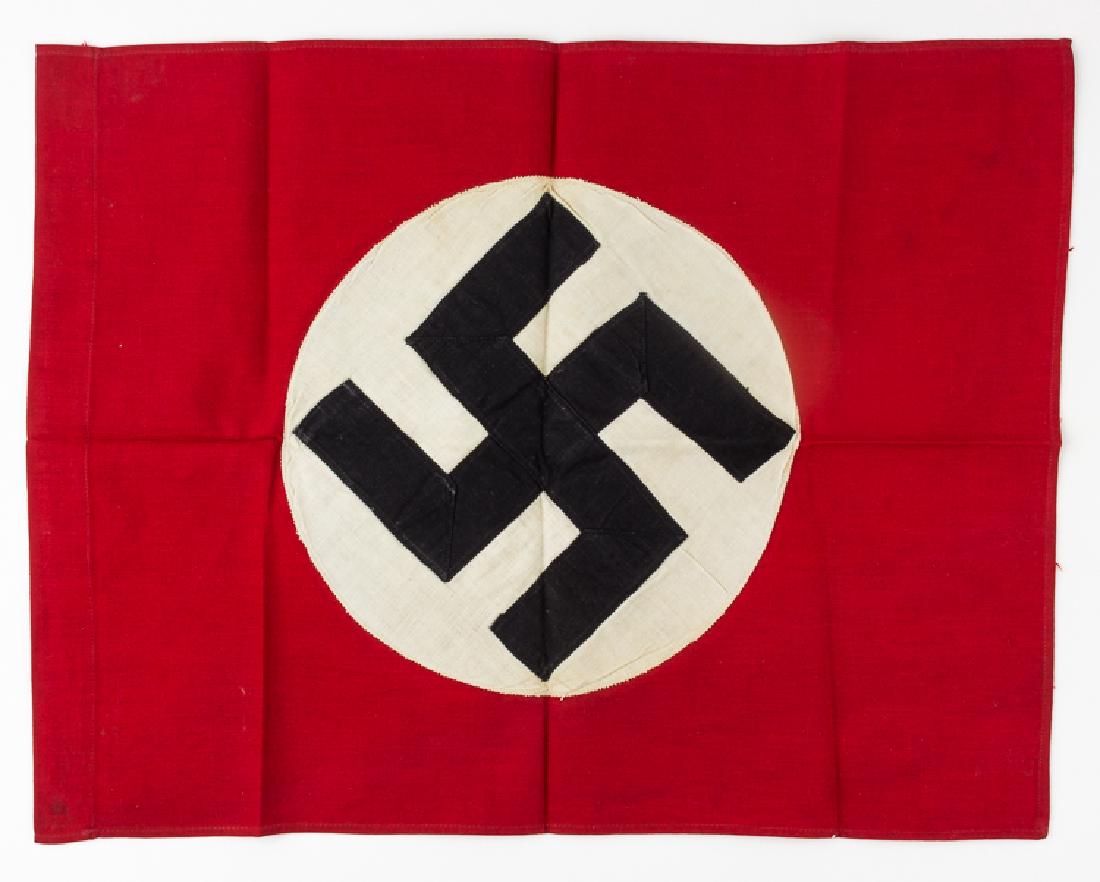NSDAP FLAG: NSDAP FLAG Original Third Reich-era flag, 18 1/2" x 14", of red wool bunting, double sided, with a white disk applied at center bearing a black fabric mobile swastika. One edge has been folded over an