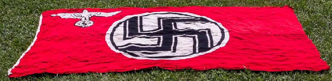 THIRD REICH STATE SERVICE FLAG: THIRD REICH STATE SERVICE FLAG Very large Third Reich "Reichsdienstflagge" or "state service flag", 132" x 74", of red cotton bunting, clamp-dyed with a stationary swastika within a white disk, with t