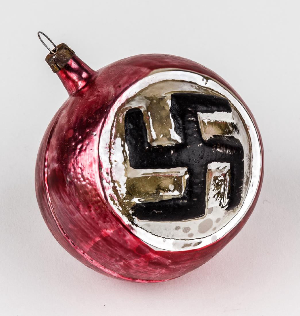 GERMAN "SWASTIKA" CHRISTMAS TREE ORNAMENT: GERMAN "SWASTIKA" CHRISTMAS TREE ORNAMENT Glass Christmas tree ornament, approx. 3" x 2 3/4" dia., a hand-painted red globe with a round silver field containing within a mobile black swastika. A small