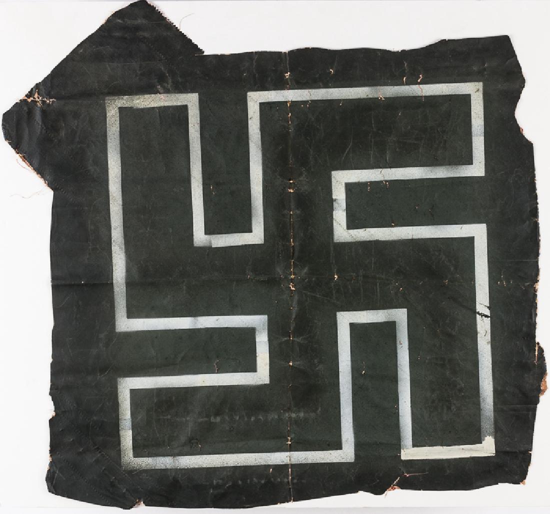 GERMAN AIRCRAFT INSIGNIA: GERMAN AIRCRAFT INSIGNIA An original German swastika insignia of the late-war outline style, executed in white spray paint on an approx. 24" x 22 1/2" dark green-painted section of doped fabric. The i