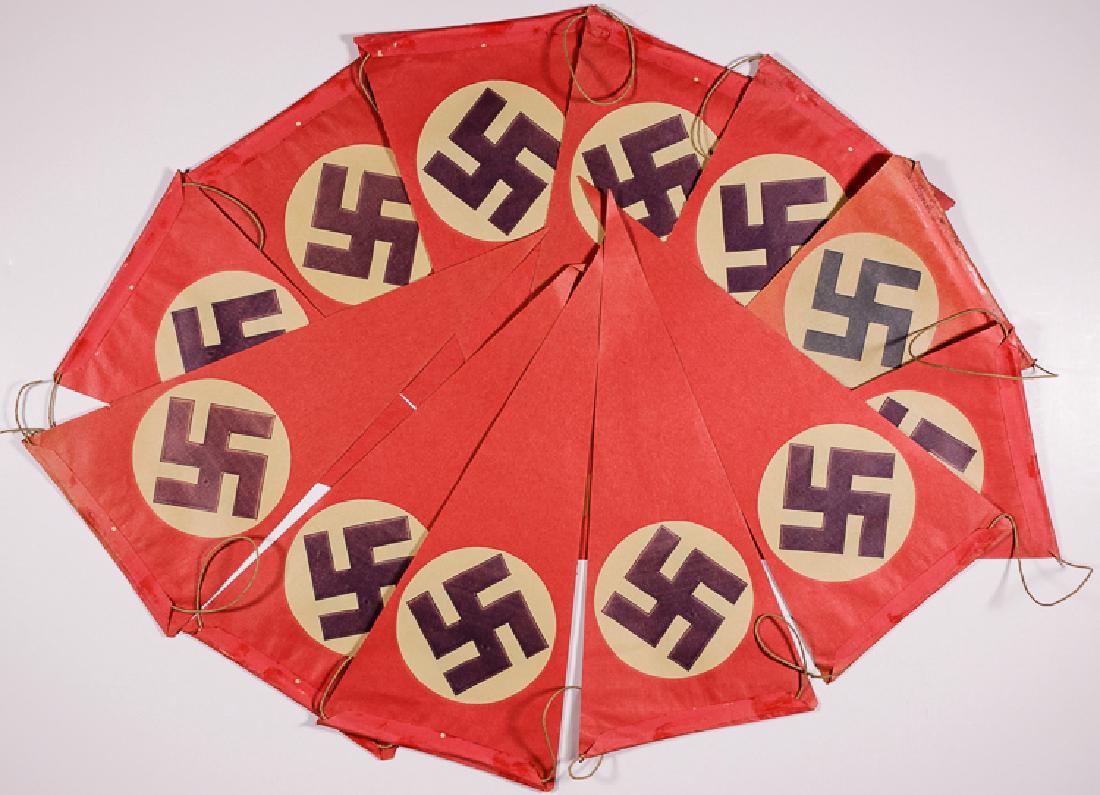 N.S.D.A.P. PAPER PENNANTS: N.S.D.A.P. PAPER PENNANTS A string of twelve 12" x 5 1/2" red paper pennants, each printed on both sides with an N.S.D.A.P. flag.The edges of several pennants are roughly cut and one is moderately fad