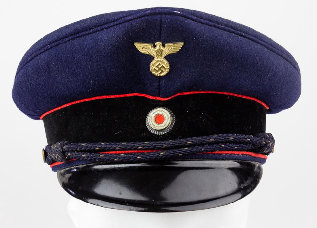 REICHSAUTOBAHN POLICE VISOR CAP: REICHSAUTOBAHN POLICE VISOR CAP Blue wool visor cap with a peaked front and black suede band, of the type worn by the Reichsautobahn Polizei. The front of the cap bears a brass national eagle, with a