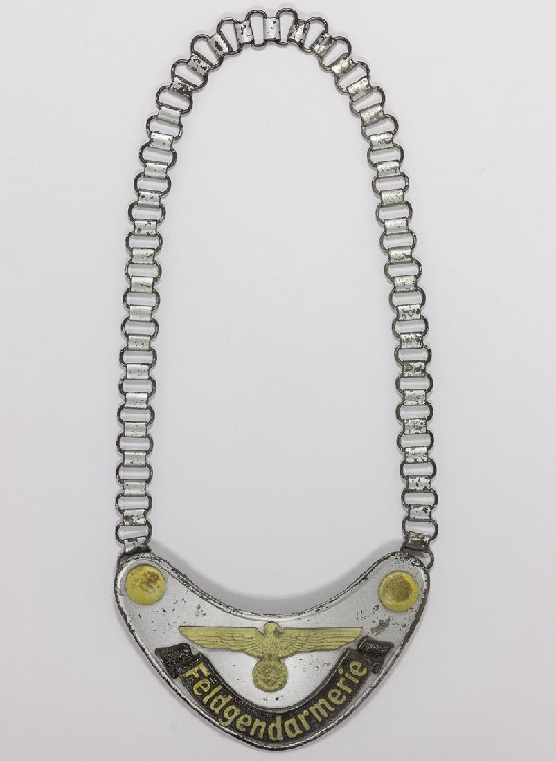 FELDGENDARMERIE GORGET: FELDGENDARMERIE GORGET "Feldgendarmerieâ€ Army field police gorget with chain. Matte aluminum face with dark grey scroll ribbon with the word â€œFeldgendarmerieâ€ and the Army straight winge