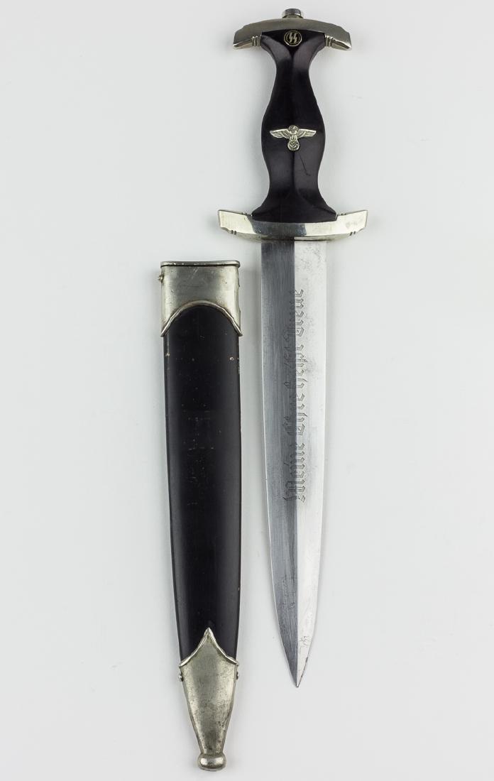 SS DAGGER WITH SCABBARD: SS DAGGER WITH SCABBARD SS dagger with scabbard. The ebony grip shows only light usage, and a hairline crack at lower crossbar is mentioned only for accuracy. The SS runes button is undamaged and a pe
