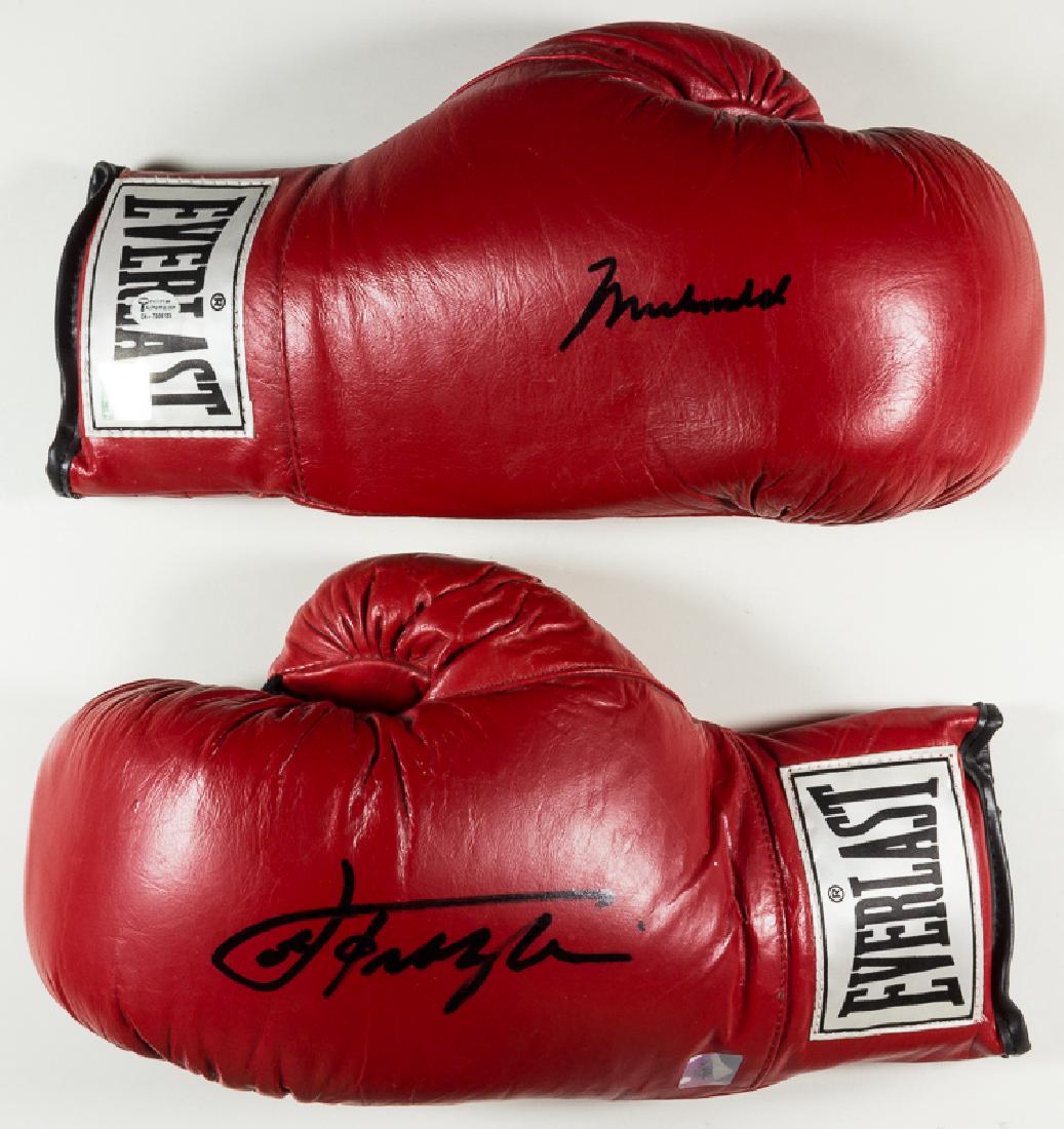 MUHAMMAD ALI AND JOE FRAZIER SIGNED GLOVES: MUHAMMAD ALI AND JOE FRAZIER SIGNED GLOVES Pair of red leather Everlast boxing gloves, each marked size 12. The right glove is signed by legendary boxer MUHAMMAD ALI (1942-2016) in black ink, while th