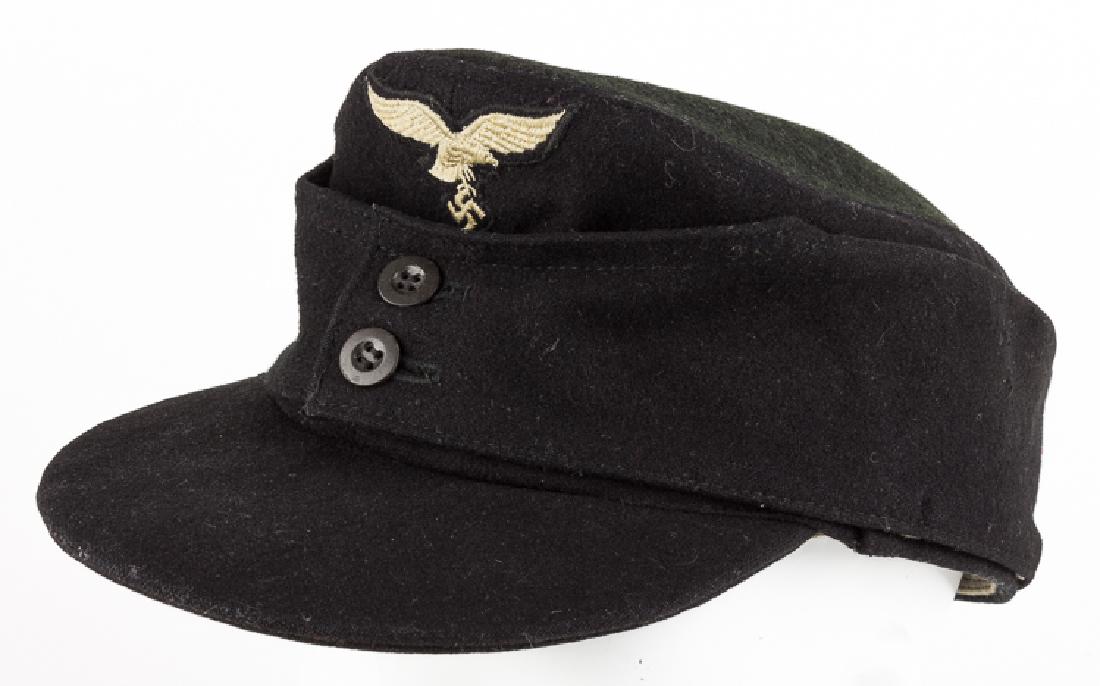 HERMANN GOERING DIVISION M43 CAP: HERMANN GOERING DIVISION M43 CAP Black wool M43-style cap, with ear flaps joined at front by two black composite buttons. The front of the cap further bears an embroidered Luftwaffe eagle patch on a b