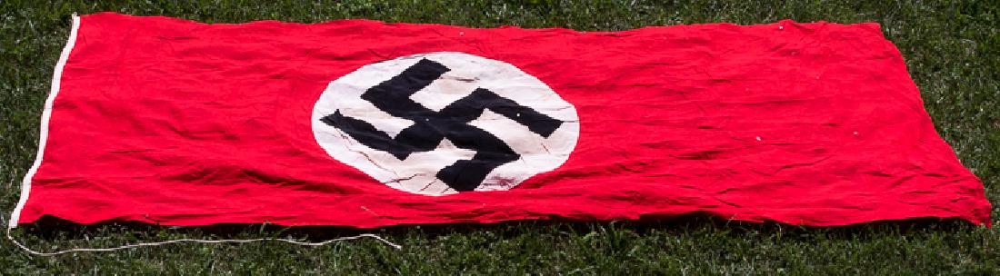 N.S.D.A.P. FLAG: N.S.D.A.P. FLAG Large double-sided NSDAP flag, 114" x 45", constructed of red wool bunting with a white disk clamp-dyed with a black mobile swastika at center. One edge bears a white fabric reinforcin