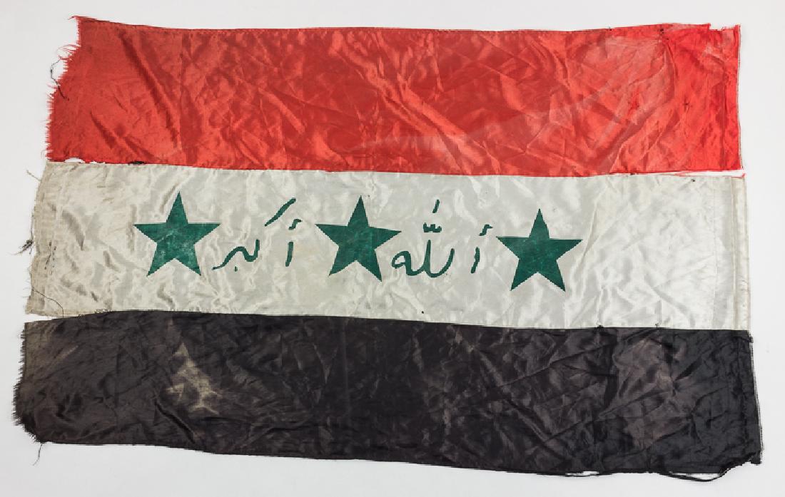 CAPTURED IRAQI FLAG: CAPTURED IRAQI FLAG Captured Iraqi national flag, 42" x 28, three-part construction with printed stars and letters, the flag now tattered and soiled, seams burst at places. The flag is accompanied by 