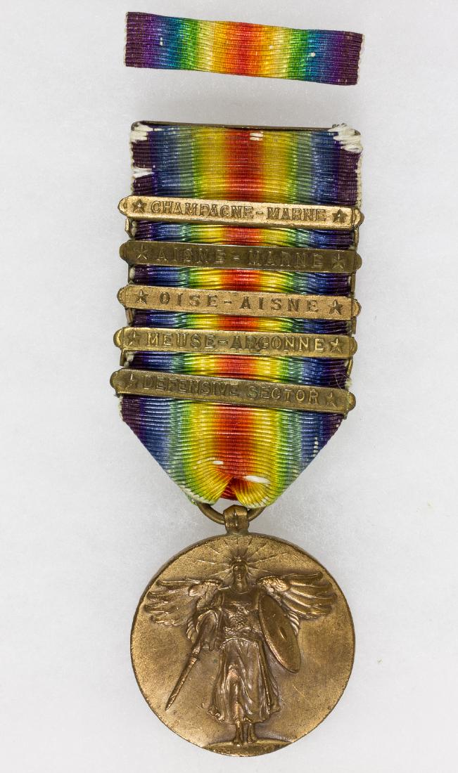 WORLD WAR I VICTORY MEDAL WITH BATTLE CLASPS: U.S. Army World War I victory medal in bronze, 1 Â½" dia., depicting s wing Victory with sword and shield on the obverse, with the reverse displaying a double-blade "fasces"Â over a U.S. shield, fl