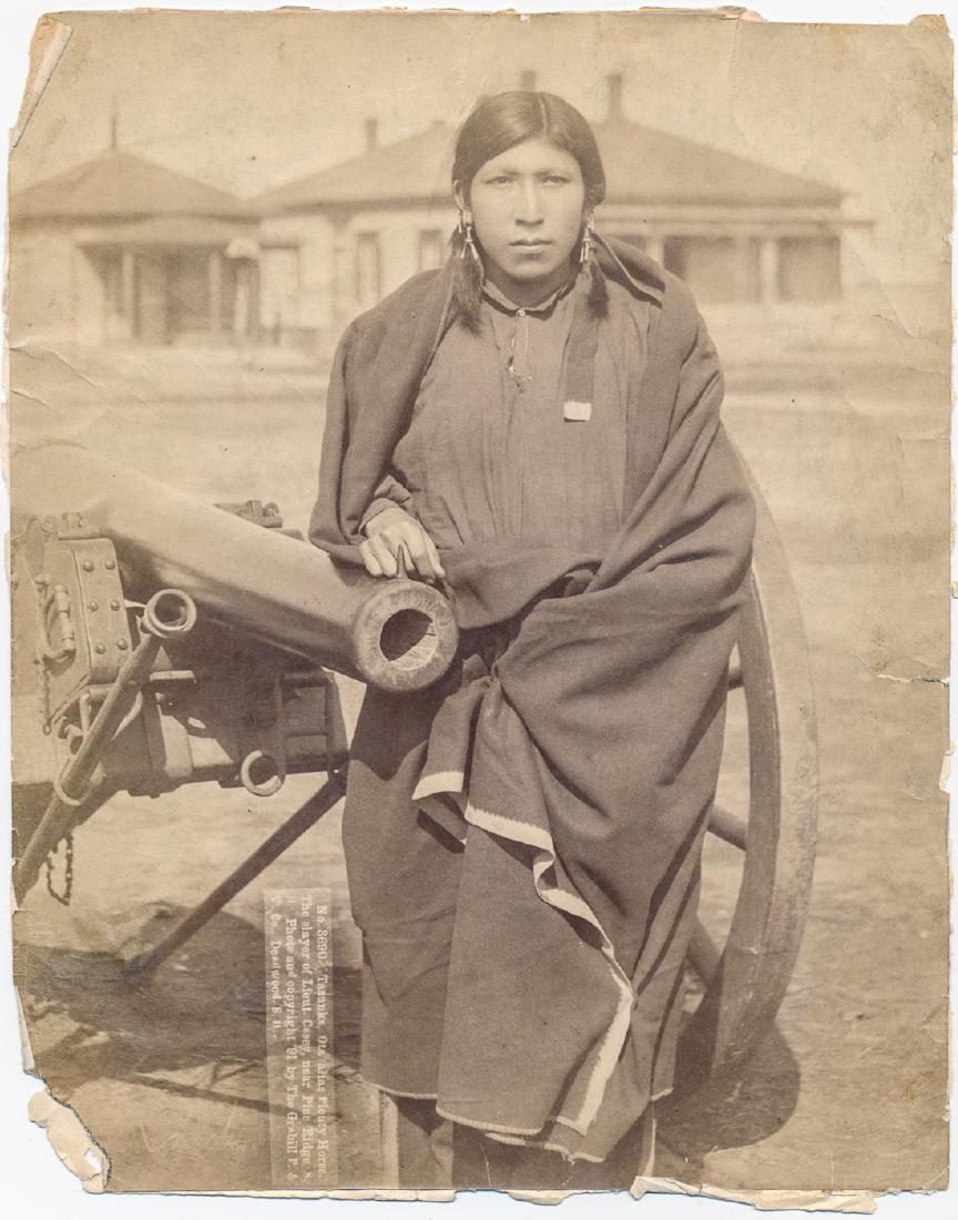 "TASUNKE, OTA...SLAYER OF LIEUT. CASEY..." BY JOHN C.: Rare mounted albumen photograph, captioned: "Tasunke, Ota (alias Plenty Horse) The slayer of Lieut. Casey, near Pine Ridge, S.D...", by John C. Grabill, 1891. The 7" x 9" photo shows Plenty Horse with