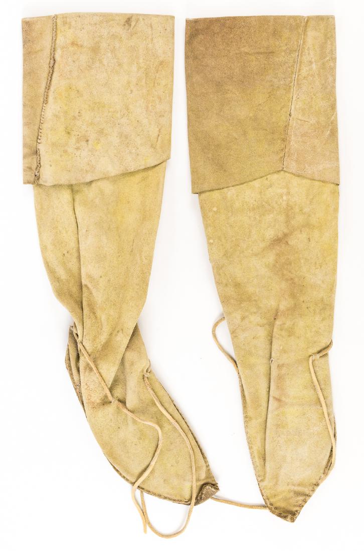 ANTIQUE INDIAN MOCCASINS: Pair on Indian calf-length moccasins with cowhide soles, the soles hand-stitched to the uppers, the sides of the uppers also hand-stitched. The soles show clears signs of use as well. Rawhide fixing l
