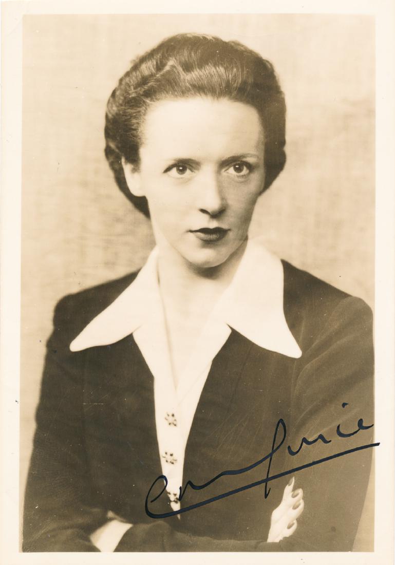 EVE CURIE: (1904-2007) French and American writer, journalist and pianist, the daughter of Nobel Prize-winning scientists Marie and Pierre Curie. S.P., 3 1/2" x 5" sepia, a chest-up view of the writer with arms 