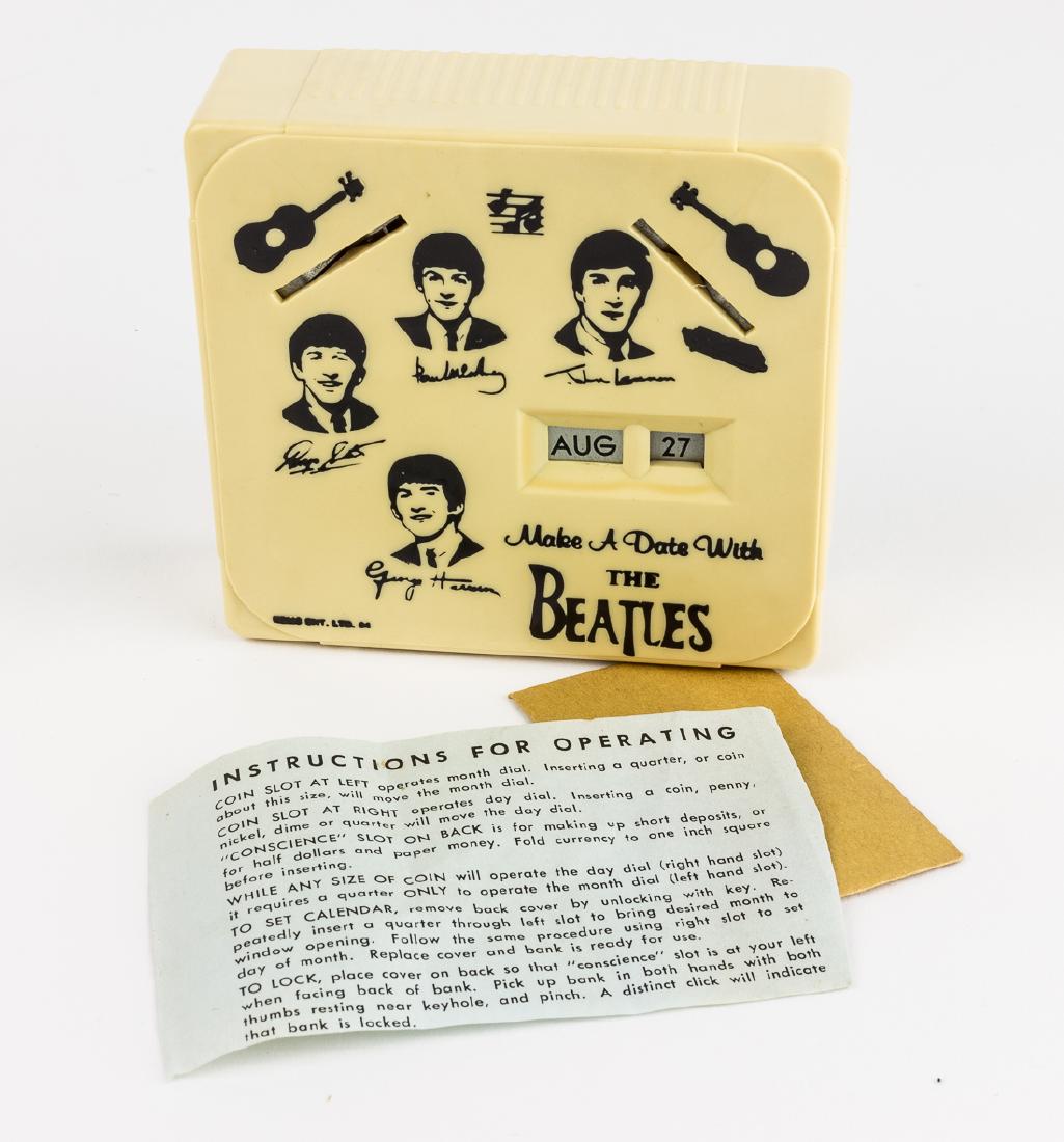 (BEATLES) "MAKE A DATE WITH THE BEATLES" BANK: Cream-colored plastic bank, 4" x 3 3/4" x 1 1/4" with printed portraits and facsimile signatures of the four Beatles, musical notes and a guitar, marked: "NEMS ENT. LTD. 64" in one corner. An ingeniou