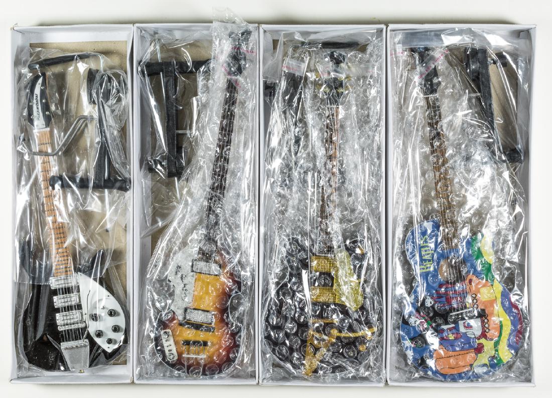 (BEATLES) BEATLES REPLICA GUITARS BY AVE HEAVEN: Lot of four miniature Beatles guitars by Axe Heaven, includes the Yellow Submarine acoustic BT-236, John Lennon Black Rick BT-265, George Harrison Country Gentleman BT265 and Paul McCartney Hoffner BT