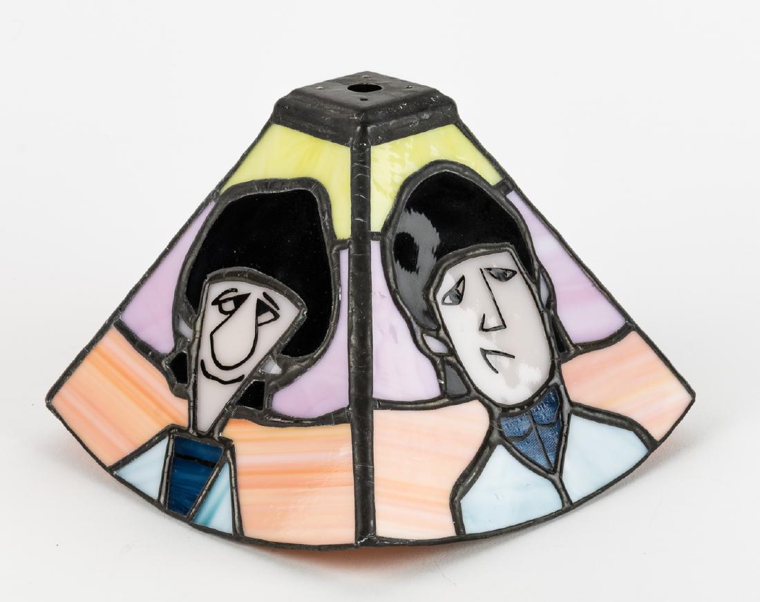 (BEATLES) CUSTOM-MADE ANIMATED BEATLES STAINED GLASS: Custom-made stained glass lampshade showing the four Beatles as they appeared in the 1960s animated television series. The 5 1/2" tall lampshade has one Beatle on each side and was expertly crafted by
