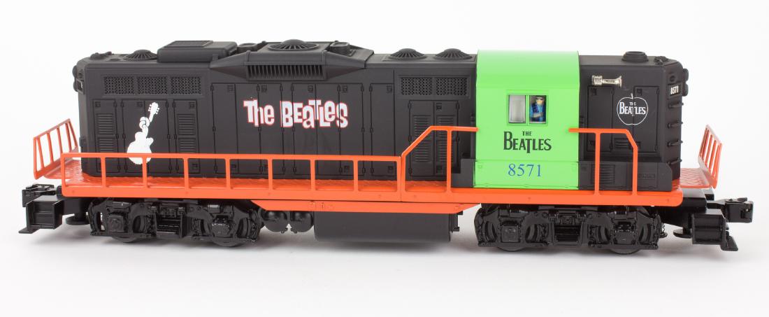 (BEATLES) LIONEL "O" GAUGE BEATLES LOCOMOTIVE: Scarce ca. 2007 Lionel "O" gauge GP-9 Diesel Locomotive, approx. 15" long, hand-painted with several Beatles logos and "knotted neck" guitar on both sides. The engine body is painted in black, with or
