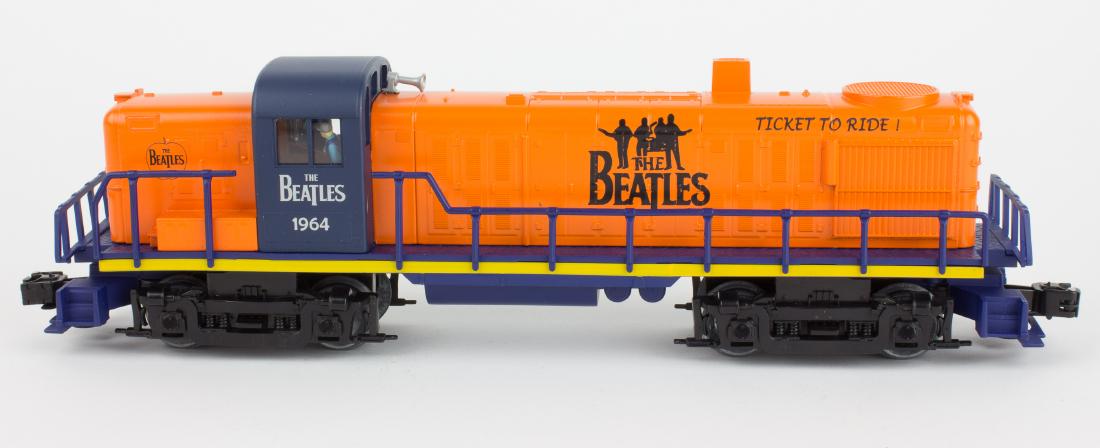 (BEATLES) LIONEL "O" GAUGE BEATLES LOCOMOTIVE: Scarce Lionel "O" gauge Diesel Locomotive, approx. 15" long, hand-painted with "1964", several Beatles logos and "Ticket to Ride!". The engine body is orange with navy blue rails and yellow trim. In n