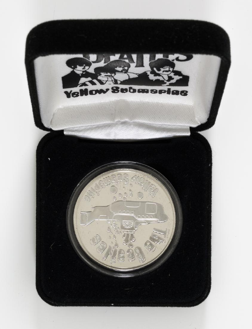 (BEATLES) STERLING SILVER YELLOW SUBMARINE COIN: Sterling silver Yellow Submarine commemorative coin with original packaging, one ounce silver with Beatles and Yellow Submarine images on the coin, issued by the Great Western Mint. Fine.