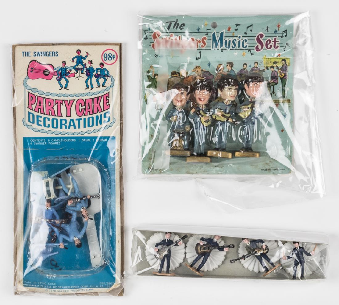 (BEATLES) VINTAGE BEATLES CAKE TOPPERS: Three sets of vintage Beatles cake toppers, all unauthorized, includes a very rare set of 3 1/2" tall bobble-head "Swingers", and an equally rare set of 2" tall figures with tabs on the verso allowing