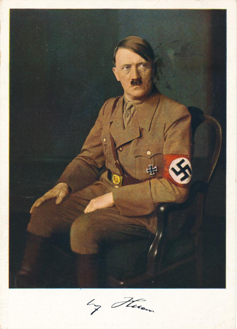 ADOLF HITLER COLOR POSTCARD: Scarce Hoffman color photo postcard of Hitler in uniform with facsimile signature in white bottom margin, canceled Vienna Mar. 16, 1939. Offset ink stain to right of face, small flaw to left, else ver