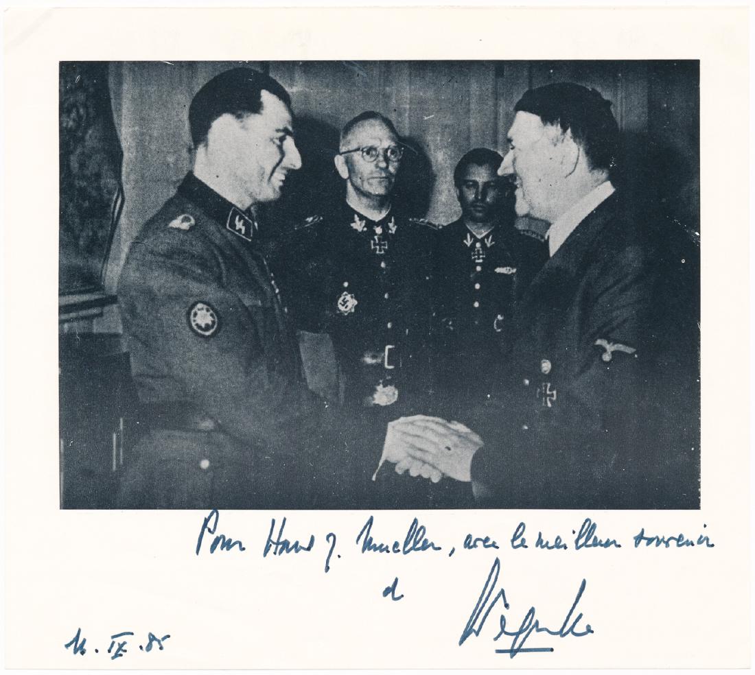 LEON DEGRELLE: (1906 - 1994) German soldier and close friend of Hitler, a Belgian volunteer in the German Army, he escaped to Spain at war's end. S.P., 8" x 7" b/w, an image of Degrelle shaking hands with Hitler, in