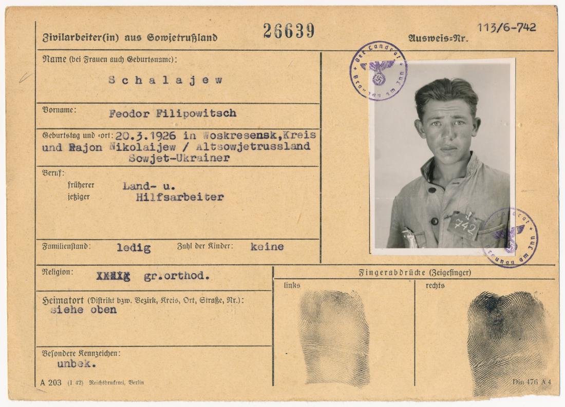SOVIET CIVILIAN LABORER'S IDENTIFICATION CARD: Partly-printed Third Reich document (unsigned), 2pp. oblong 8vo., an identification card for Soviet civilian laborer Feodor Filipowitsch Schalajew, bearing his identity photo, thumbprints, and place a
