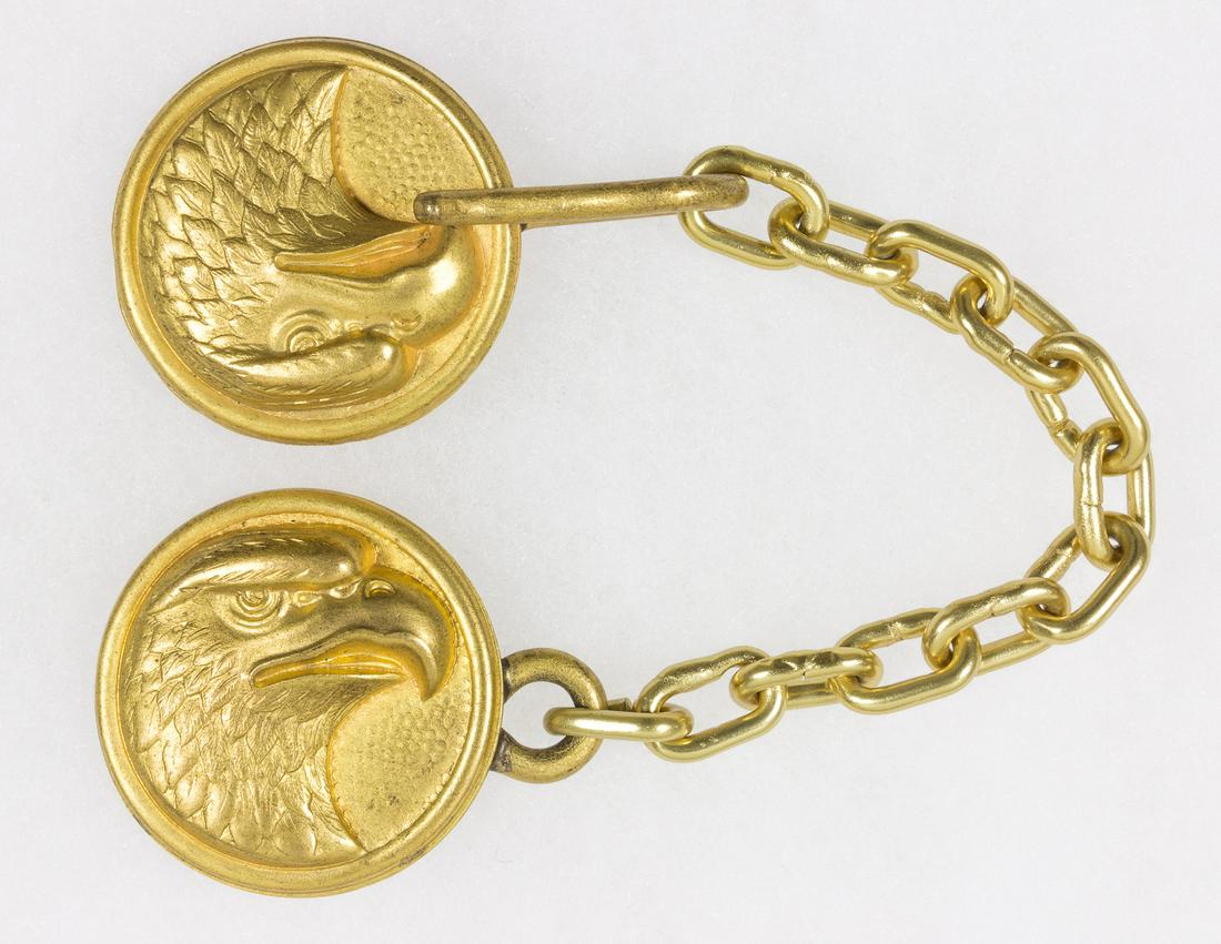 LUFTWAFFE GENERAL'S CAPE CLASP: Luftwaffe general's cape clasp, consisting of a pair of 1.25 in. dia. gilt metal disks depicting an eagle's head in high relief, joined by a 4.25 in. gilt chain. The reverse of each disk is fitted wit