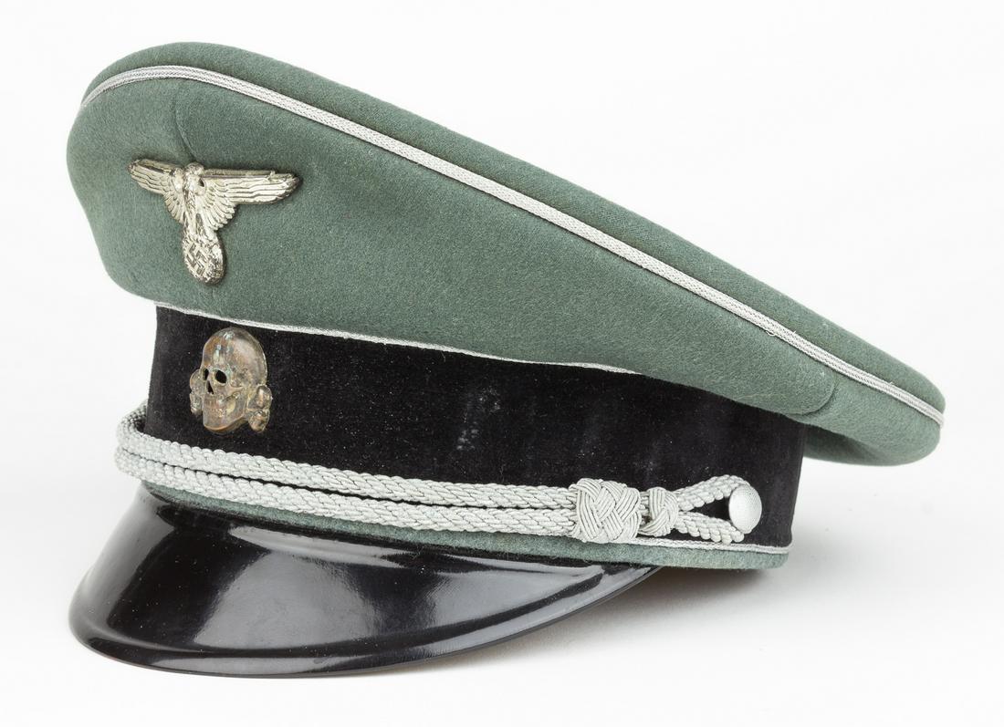 SS GENERAL'S VISOR CAP: A fine example of a Waffen-SS general's visor cap, constructed of field-grey wool with a black velvet band and showing a subtle 'saddle' shape. An SS-style shell metal national eagle insignia is affix
