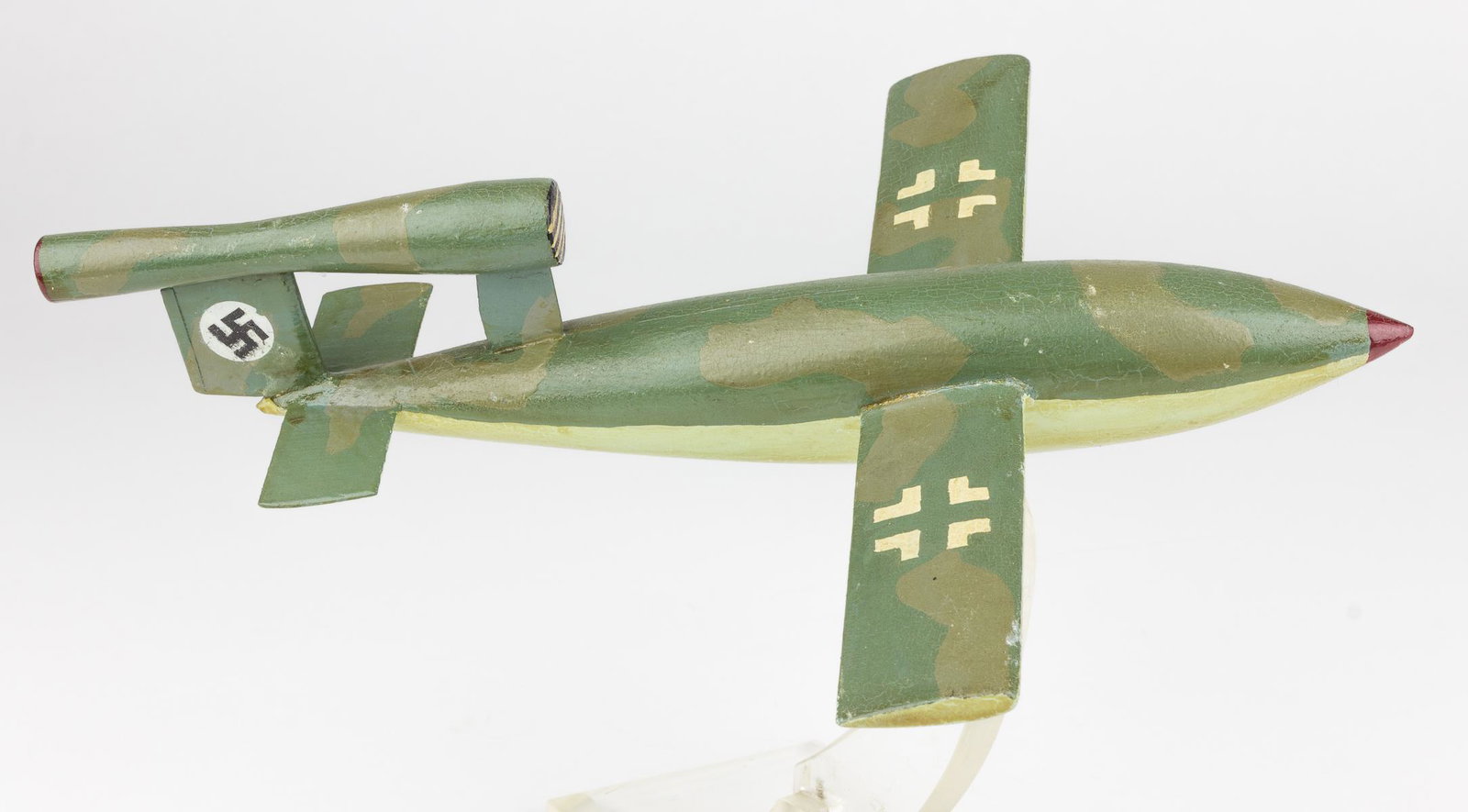 V-1 FLYING BOMB DESK MODEL: Finely-crafted desk model of a German V-1 flying bomb, approx. 10 1/2' x 8', hand-made from wood and hand-painted with a green and olive camouflage scheme and Luftwaffe insignia. The model is mounted 